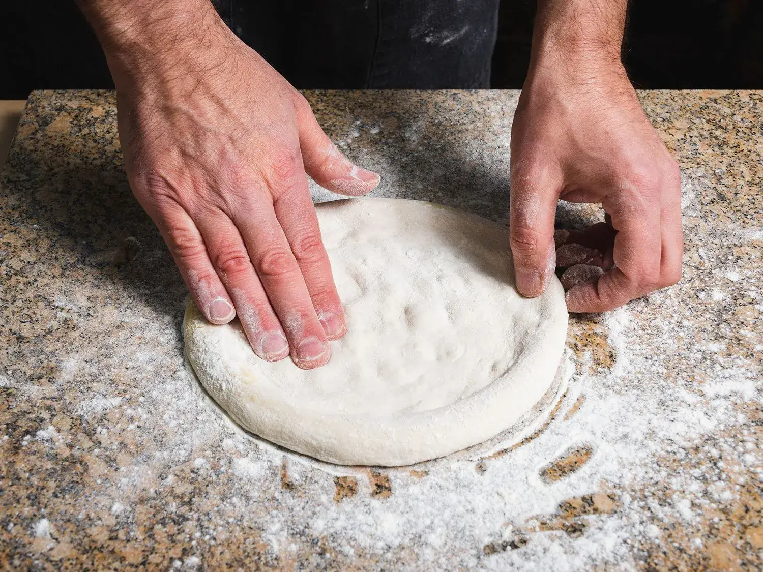 Freshly made pizza dough being kneaded.