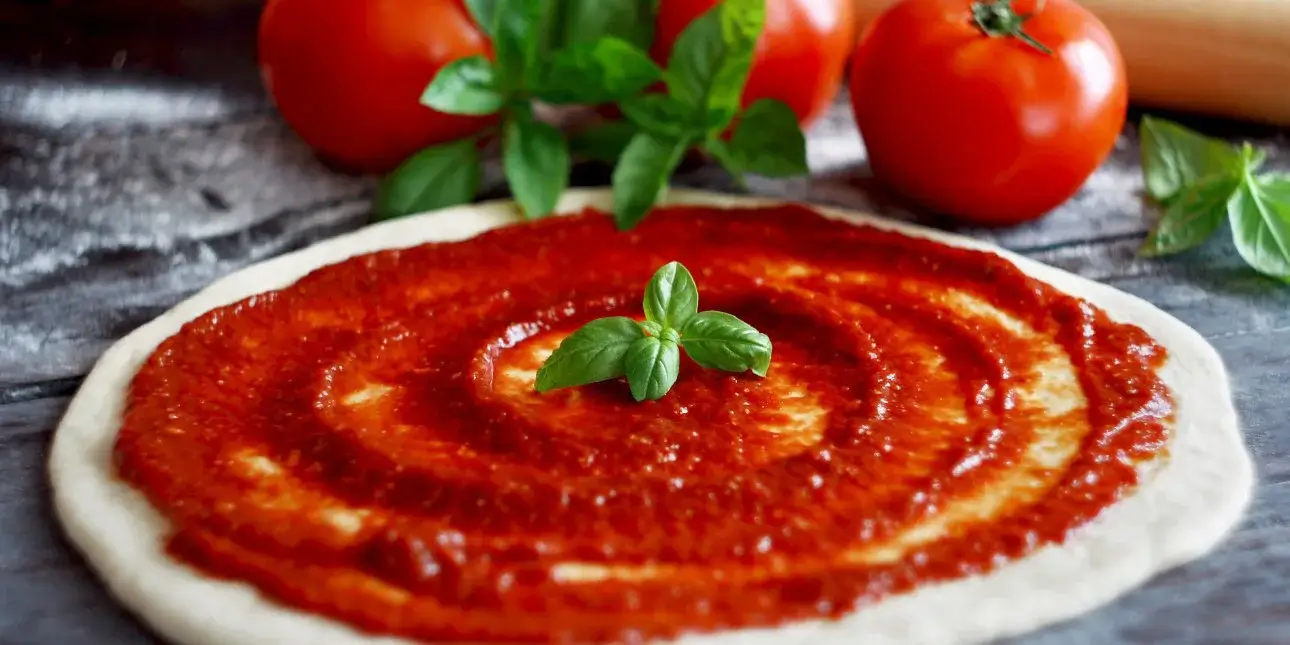 Close-up of fresh basil and tomato sauce